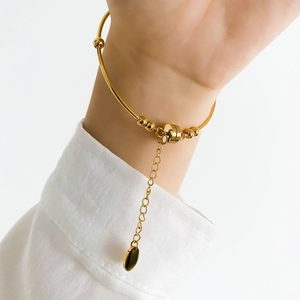 Close-up of golden pearl bracelet with metal beads and adjustable chain on wrist