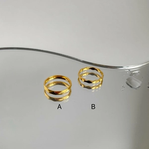 Details von facettierten geometrischen und wellenförmigen Goldringen aus Titanstahl