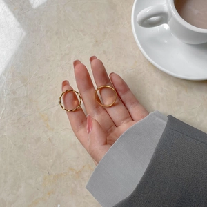 Französisches minimalistisches Gold-Titanstahl-Ring-Set auf Marmorhintergrund präsentiert