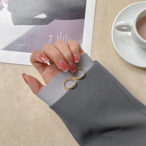 Details von minimalistischen vergoldeten Ringen vor elegantem Lifestyle Hintergrund
