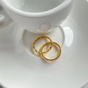 Nahaufnahme von goldenen Titanstahlringen mit gewellter Textur und glattem Finish