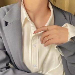 Detailed view of minimalist 18K gold plated titanium steel rings with a small white zircon
