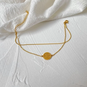 Detail of double-layer gold plated snake chain with hollow round pendant and lobster clasp