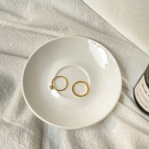 Close-up of a 18K gold plated ring set with a square zircon stone on a white tray