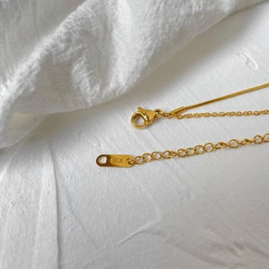 Macro view of gold plated chain with lobster clasp and K18 engraving detail