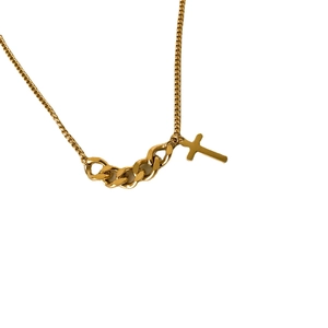 Collier doré avec maille gourmette et pendentif croix minimaliste sur un fond blanc pur