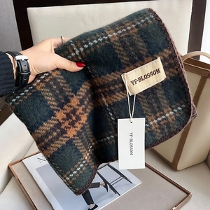Détail d'une écharpe à carreaux vintage douce avec étiquette de marque textile
