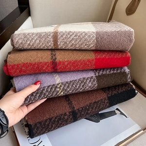 Soft checkered scarves in various colors including caramel and purple with fringe detail