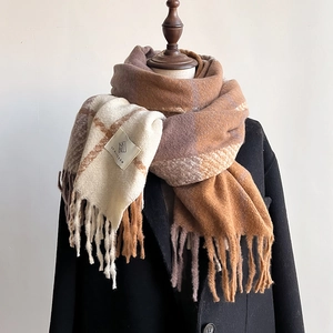 Thick plaid scarf with fringe in beige and caramel tones on black winter coat