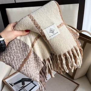 Macro shot of thick winter plaid scarf with fringe detail and soft cashmere-like texture