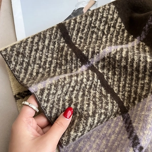 Close-up of thick plaid scarf fabric texture in brown and purple with soft knit fibers
