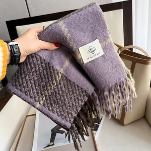 Detail of purple plaid cashmere-feel scarf featuring soft long tassels and woven brand label