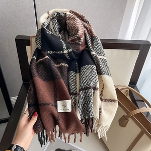 Close-up of thick checkered scarf with tassels draped on a wooden chair for winter warmth
