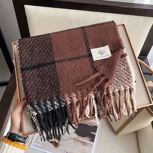 Detail of checkered cashmere shawl showing thick texture and brand tag on fringes scarf