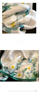 Détail d'un foulard en soie à fleurs bleu-vert montrant la texture lisse et l'ourlet