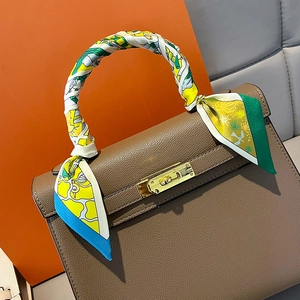 Classic brown leather handbag with colorful geometric print silk scarf on top handle