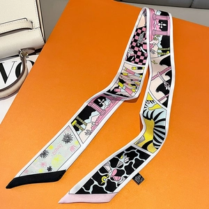 Detail shot of a silk twilly scarf with vibrant prints on an orange background