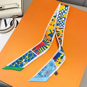 Detailed view of 100% silk twilly scarf featuring vibrant prints on orange luxury gift box