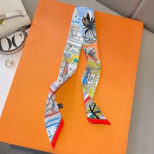 Floral print narrow silk twilly scarf for women displayed on an orange luxury gift box