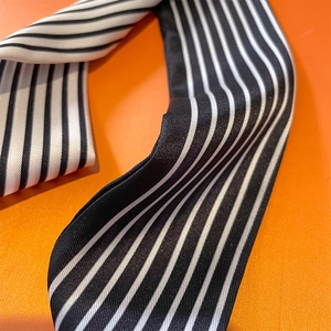 Gros plan d'un foulard en satin à rayures noires et blanches avec une texture fine et soyeuse