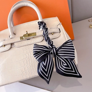 Sac à main élégant blanc à relief crocodile avec foulard rayé noir et blanc sur l'anse