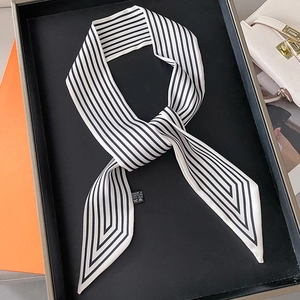 Élégant foulard étroit à rayures diagonales noires et blanches sur un plateau noir mat