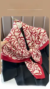 Detail of burgundy floral silk scarf with abstract rose pattern and smooth satin finish
