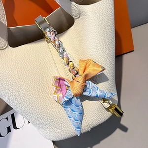 White pebbled leather bucket bag with colorful silk scarf and gold lock hardware