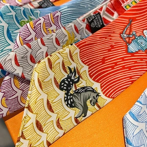 Polyester twilly scarves with vibrant seahorse patterns stacked on a signature orange gift box