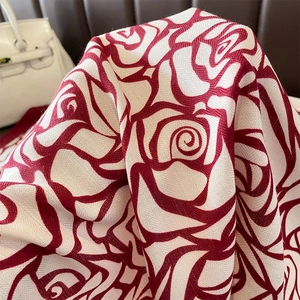 Detail of red rose floral jacquard on soft cream twill fabric with silk-like texture