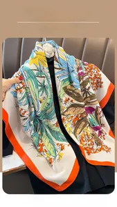 Detail of colorful vintage floral print silk scarf with smooth texture and orange border