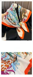 Close-up of vibrant tropical floral silk scarf with hand-stitched orange rolled edges