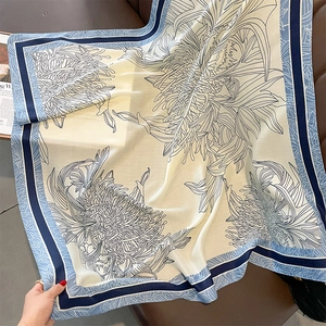 Macro view of lightweight silk scarf featuring vintage floral print and stripe borders