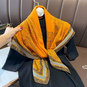 Elegant bright orange silk-like scarf with black botanical patterns and brown borders