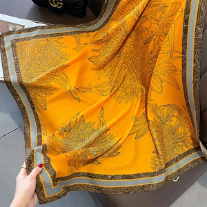 Detail of soft yellow sunflower print scarf with geometric striped border finish
