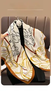 Détail du foulard effet soie avec motifs floraux abstraits et bordure marron