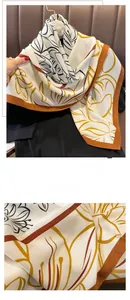 Détail de l'écharpe en laine avec ourlet orange et imprimé de feuilles d'automne