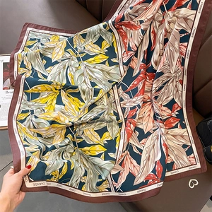 Detailed close-up of retro floral silk scarf with foliage pattern and CHANGE print