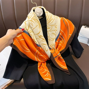 Écharpe à fleurs orange et crème avec texture douce en soie et contours dorés