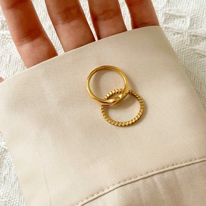 Detailed close-up of a stackable gold ring set featuring smooth and textured bands