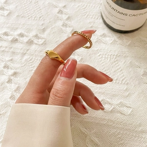 Close-up of minimalist gold heart-shaped ring set worn on model's hand