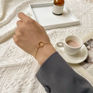 Elegant gold double interlocking rings bracelet on female wrist with French aesthetic