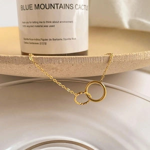 Minimalist double interlocking circle pendant necklace in gold with textured twist detail