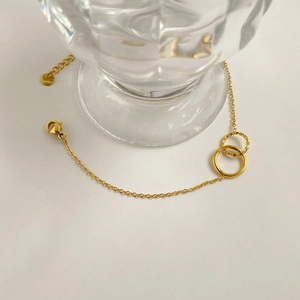 Detail of gold double interlocking rings bracelet with smooth and twisted textures
