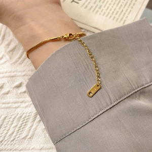 Macro shot of 18K gold bracelet with lobster clasp and adjustable extension chain link