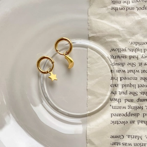 Vue détaillée des boucles d'oreilles créoles asymétriques étoile et lune en or brillant