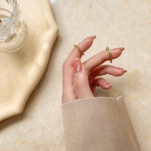 Detail of gold braided chain ring and twisted rope ring set on model fingers