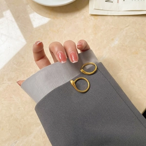 Minimalist 15k gold plated geometric rings styled on grey blazer sleeve cuff