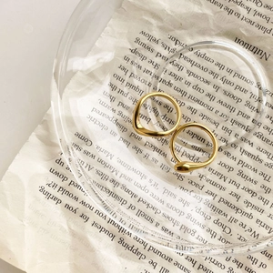 Close-up of 15k gold plated geometric snake ring with irregular wavy band on vintage paper