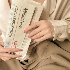 Detail of minimalist gold-plated titanium stackable rings worn in a lifestyle setting